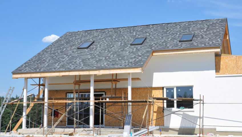 A beautiful house with panoramic windows, skylights, glass door, and white walls during painting and renovation.